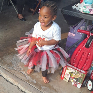 Jordyn wears a red tutu and smiles on her adoption day